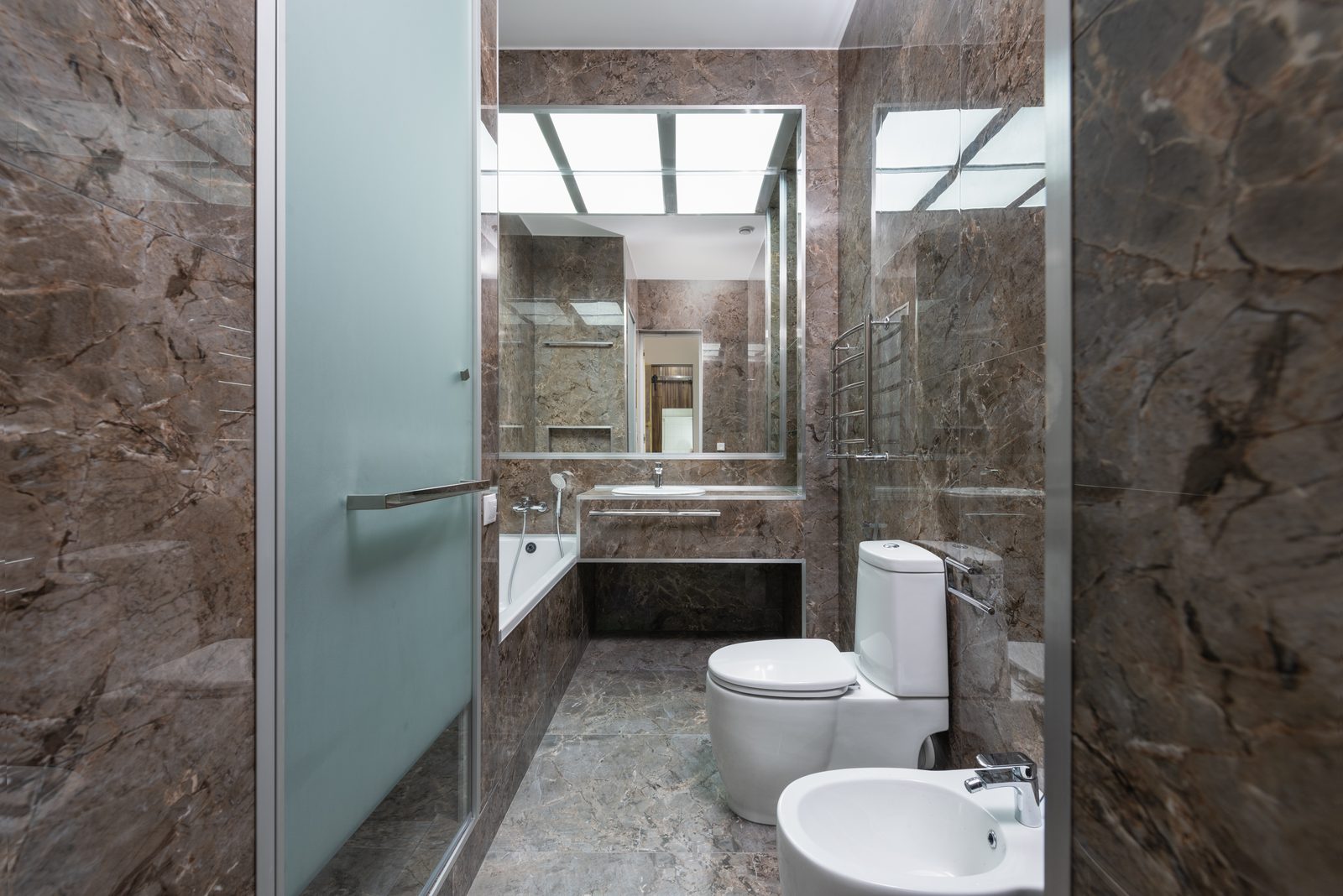 Bathroom interior with premium tiling at Raheja Reserve by Viona Interiors