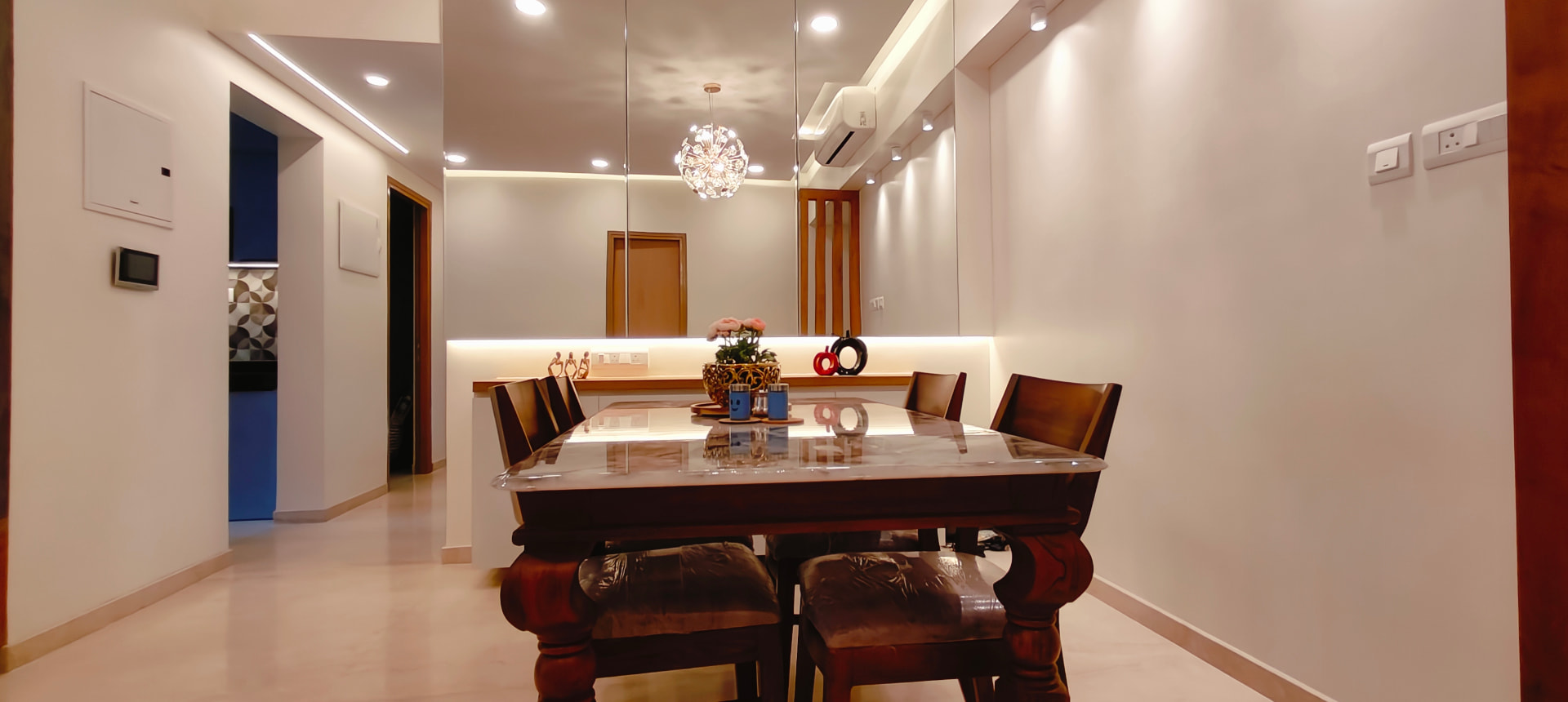 Dining area with mirror wall at Lodha Bella Vita by Viona Interiors