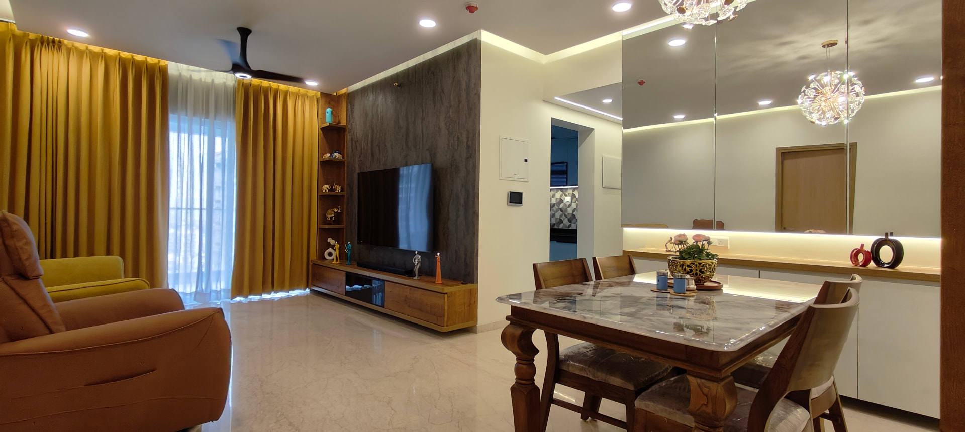 Living room with TV unit and mustard accents at Lodha Bella Vita by Viona Interiors
