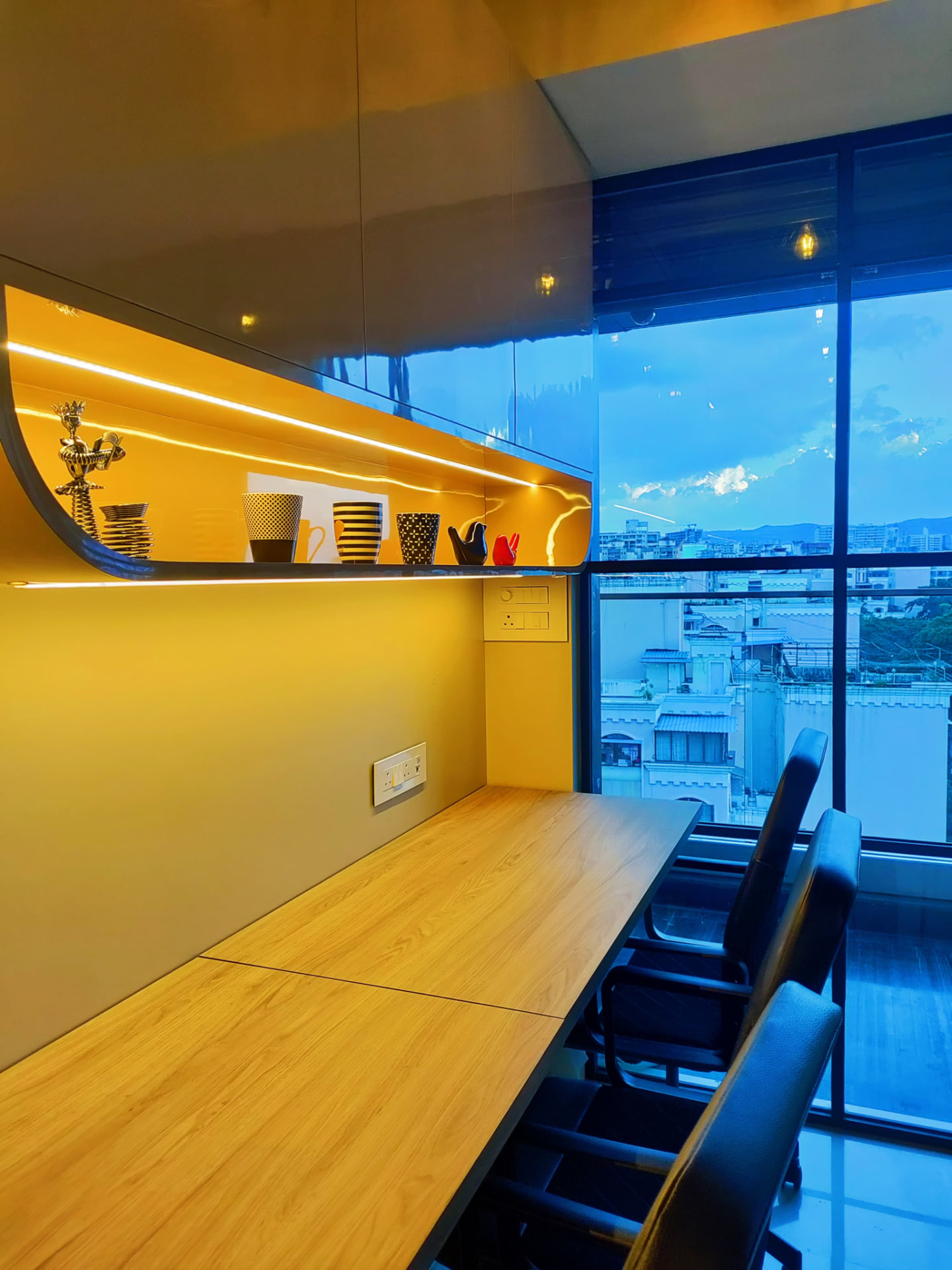 Workstation with long wooden desk and city skyline view