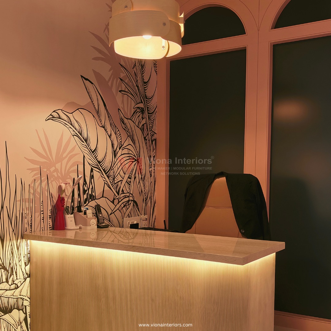 Reception desk with botanical mural and brass lighting at Viona Interiors office